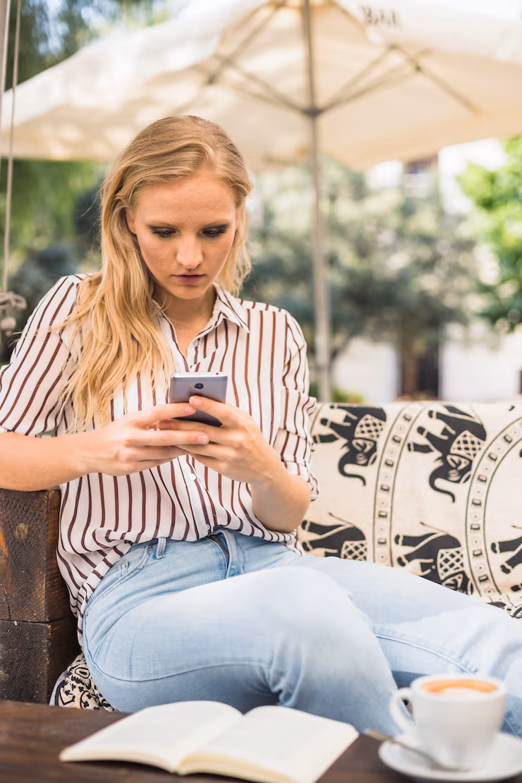 young-woman-texting-messages-smartphone-sitting-outdoor-with-coffee-book_23-2147862845